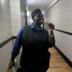 Hotel Employee Stands in Hall Holding Key Card