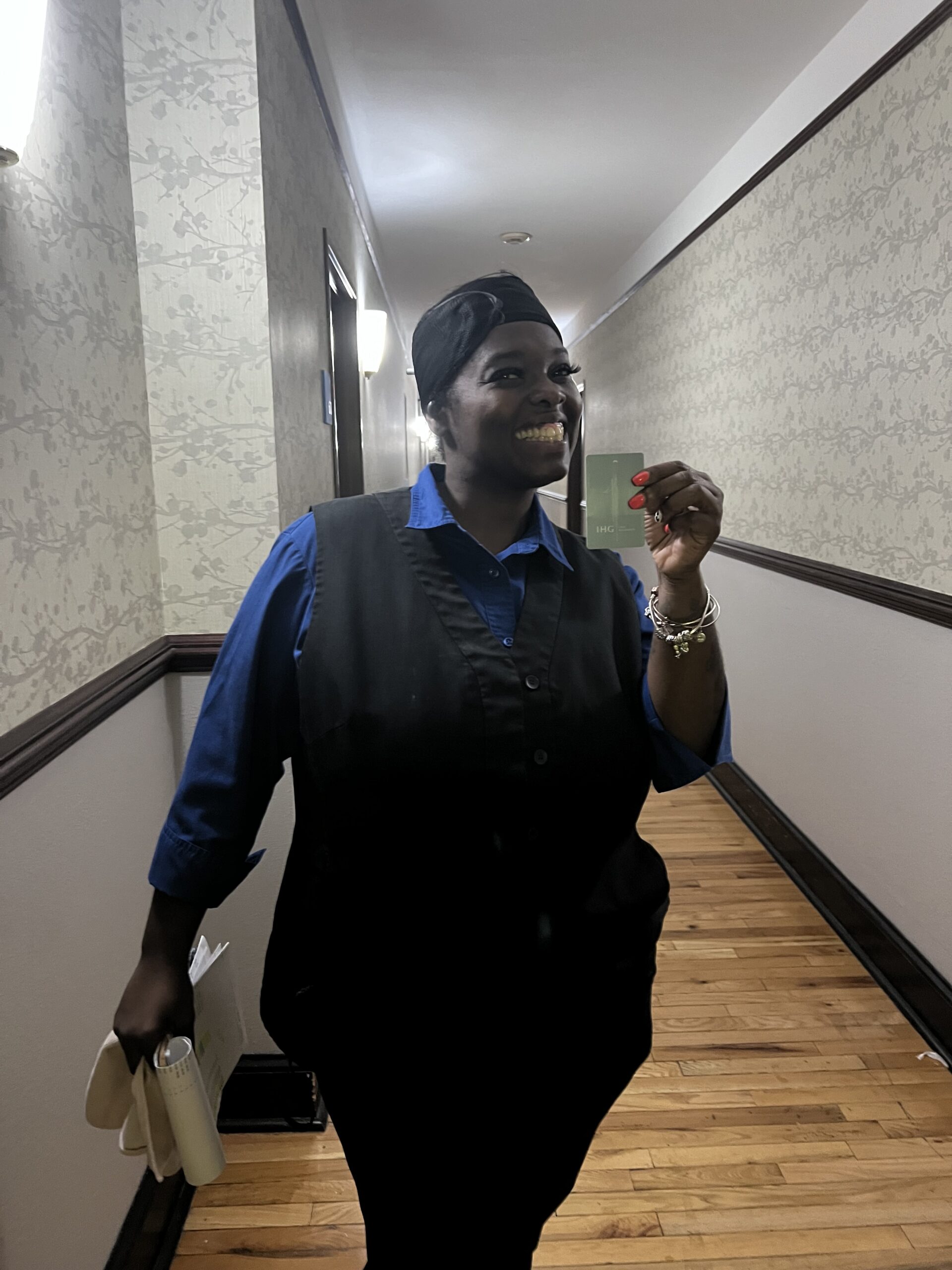 Hotel Employee Stands in Hall Holding Key Card