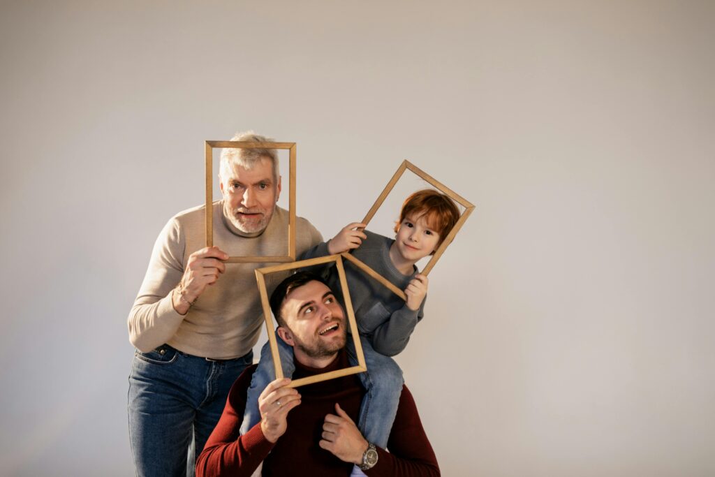 a Boy and Two Men Holding Photo Frames