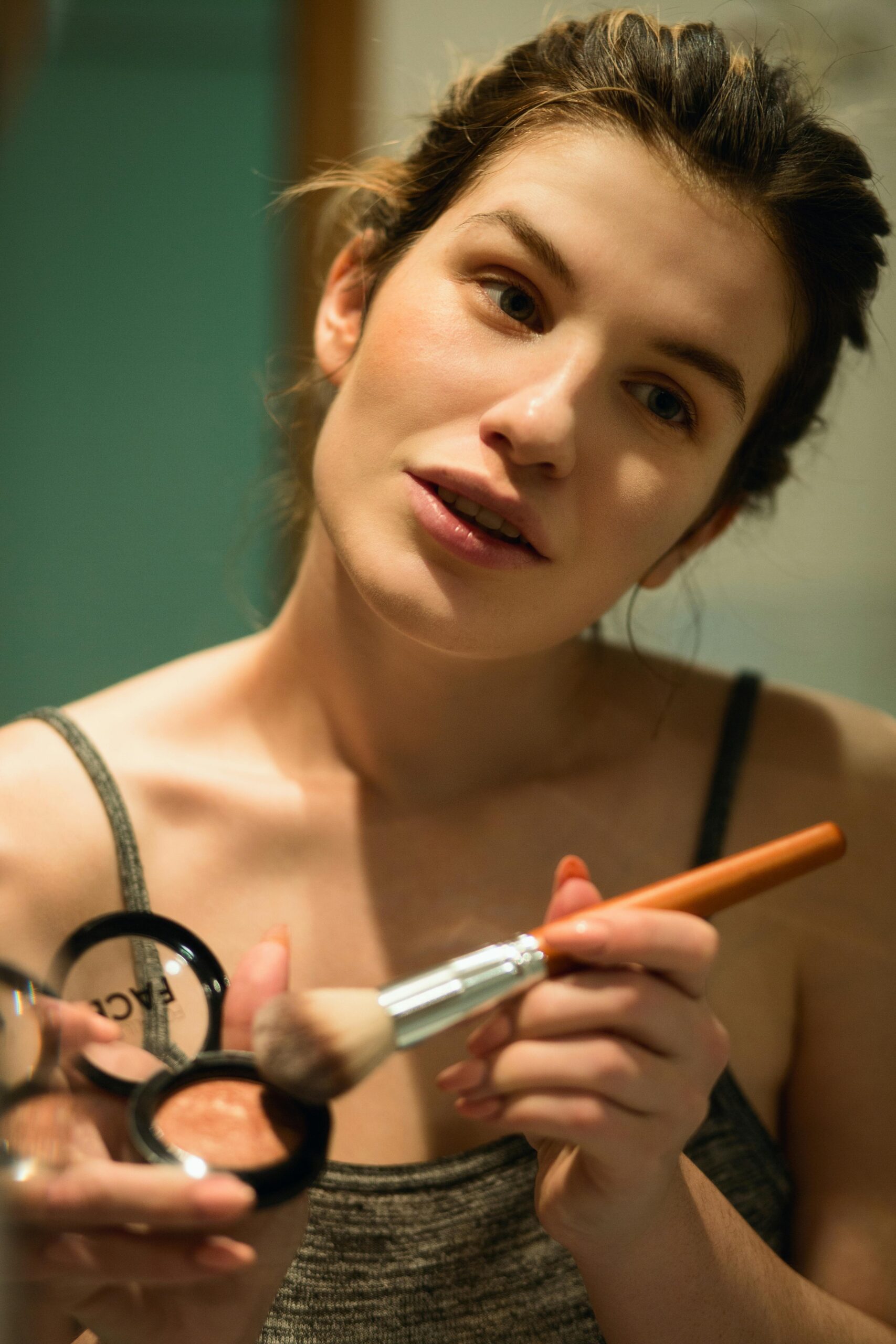 Woman putting on makeup with a brush