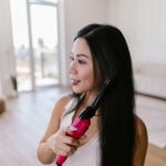 Woman Curling Her Hair with a Curling Iron