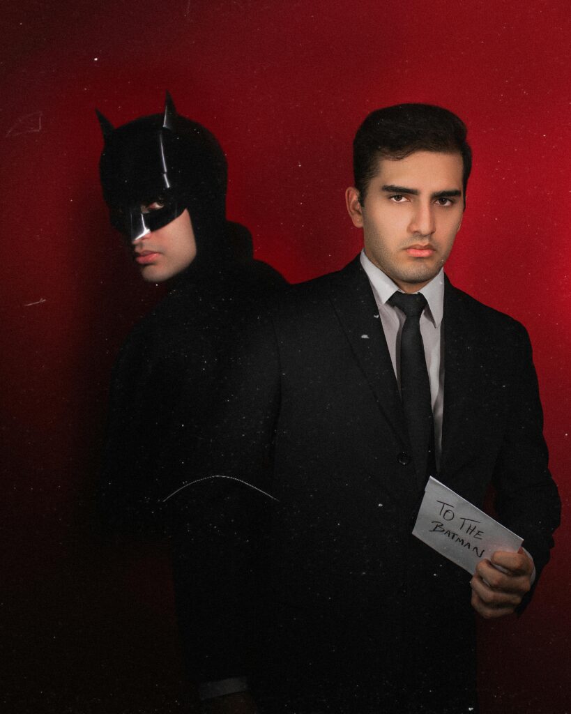 One Man Dressed As Batman and One Man Holding an Envelope Addressed to the Batman