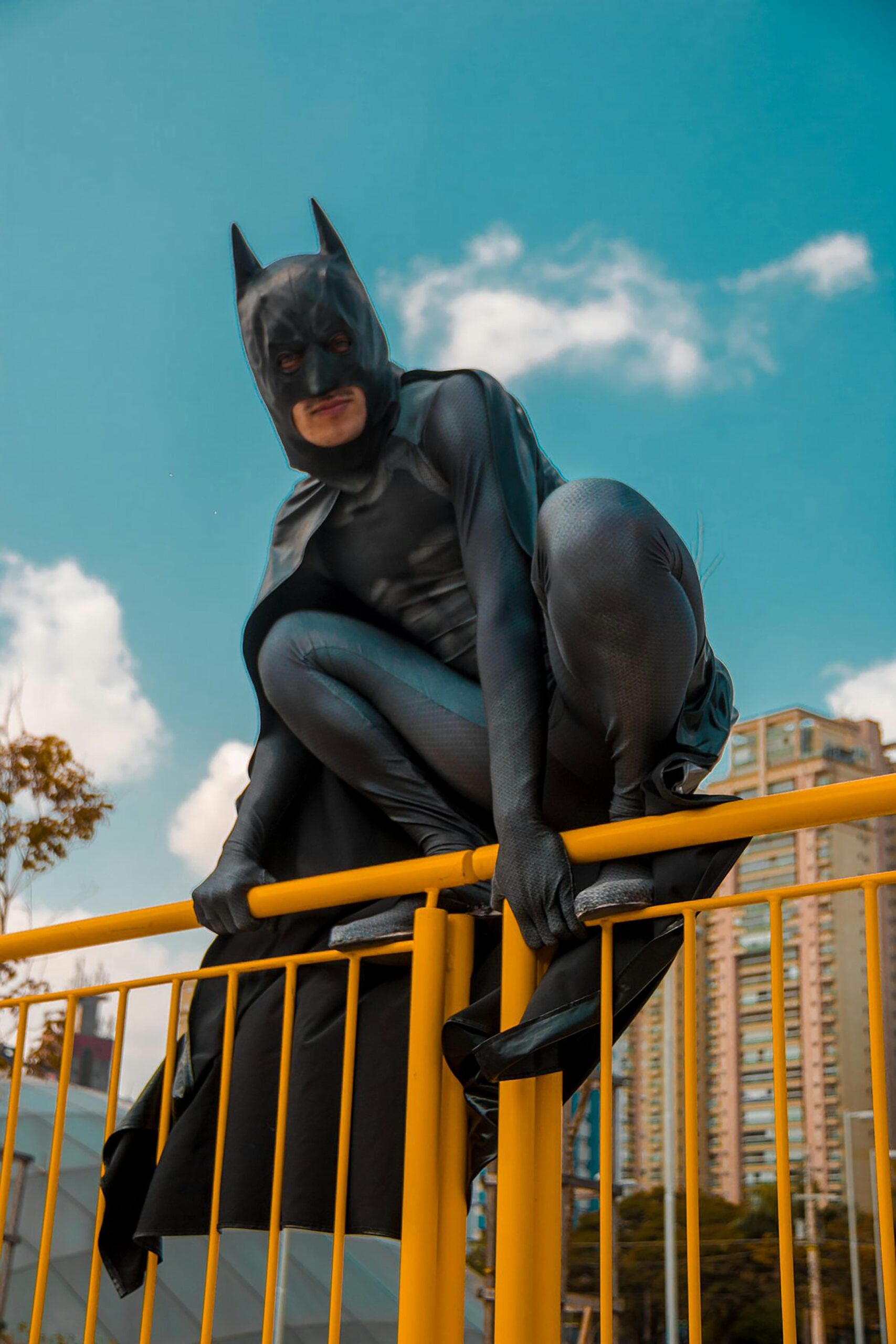 A person dressed as Batman on a railing