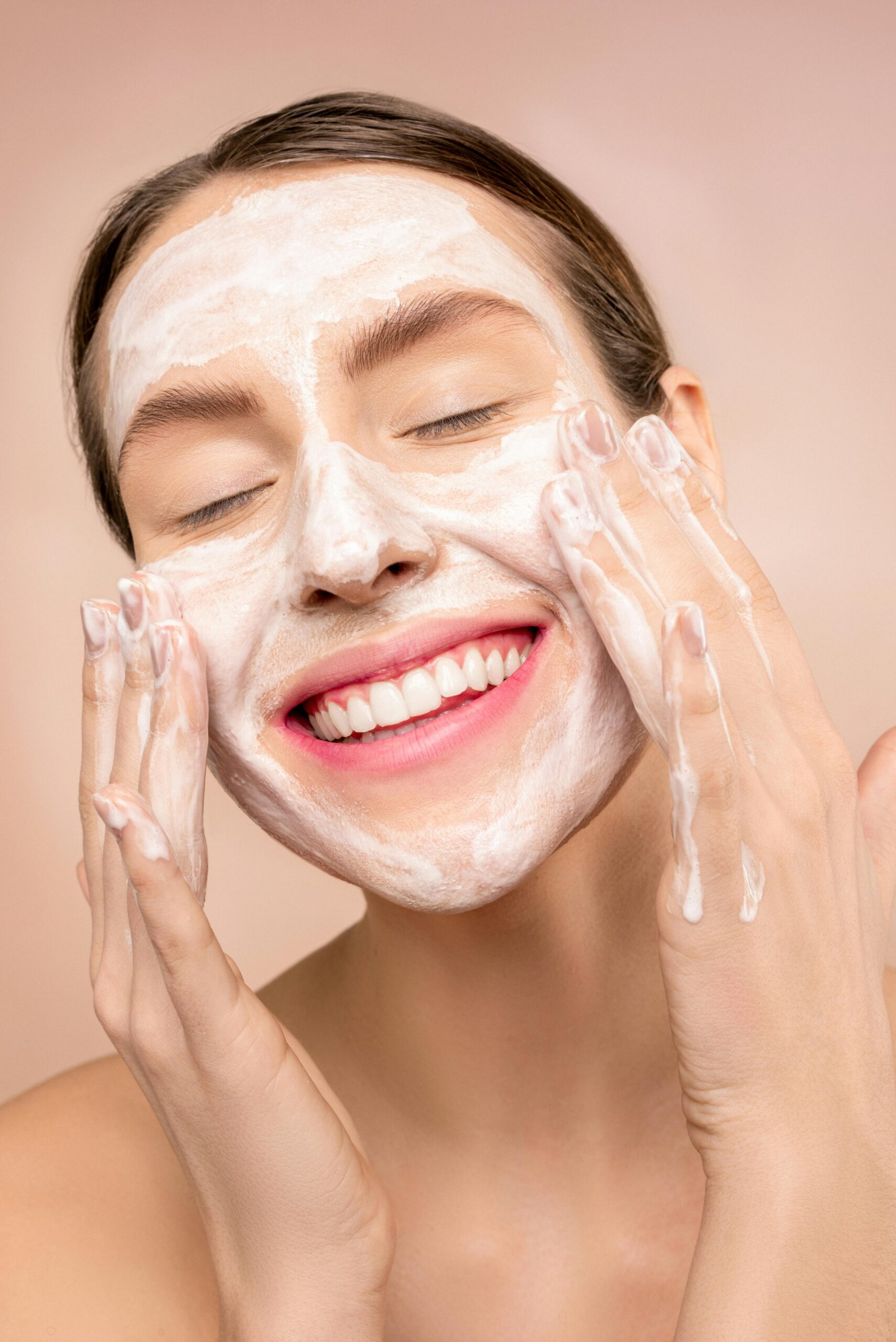 Woman smiling while she washes her face