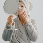 Woman Looking into a Mirror Wearing a Facemask