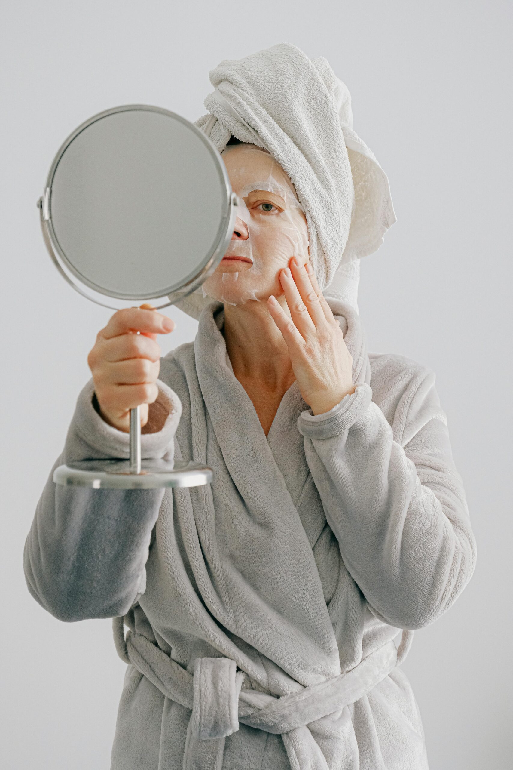 Woman looking into a mirror wearing a facemask