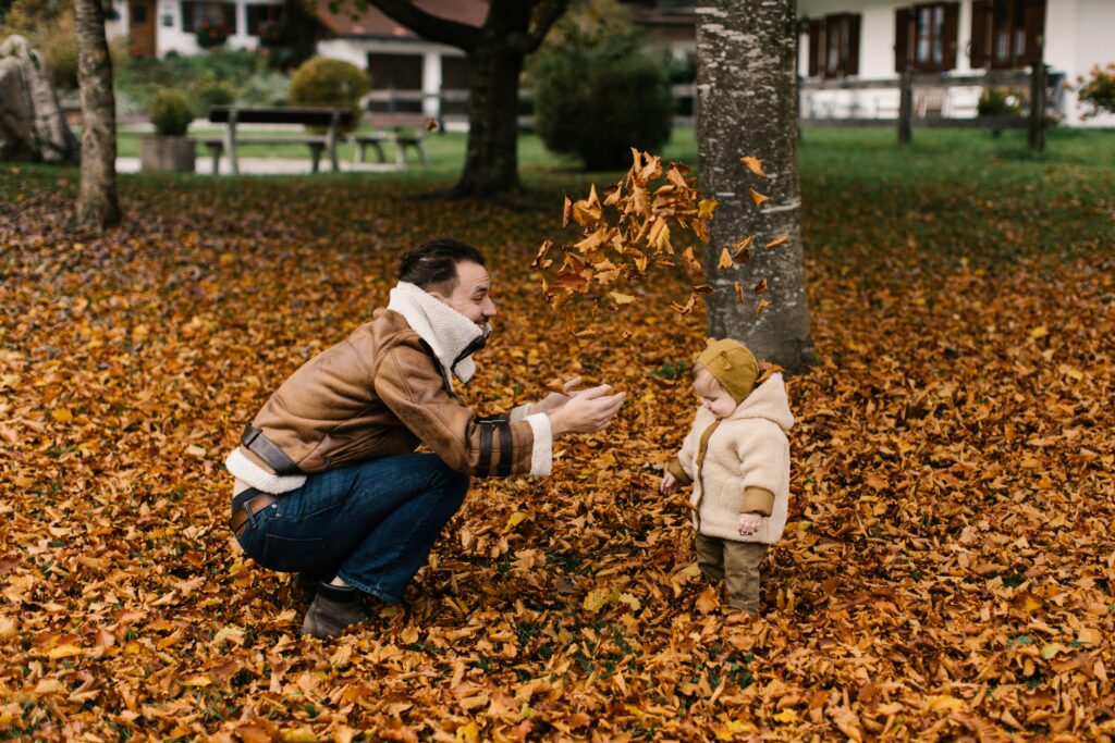 Man in Fall Leaves with Toddler