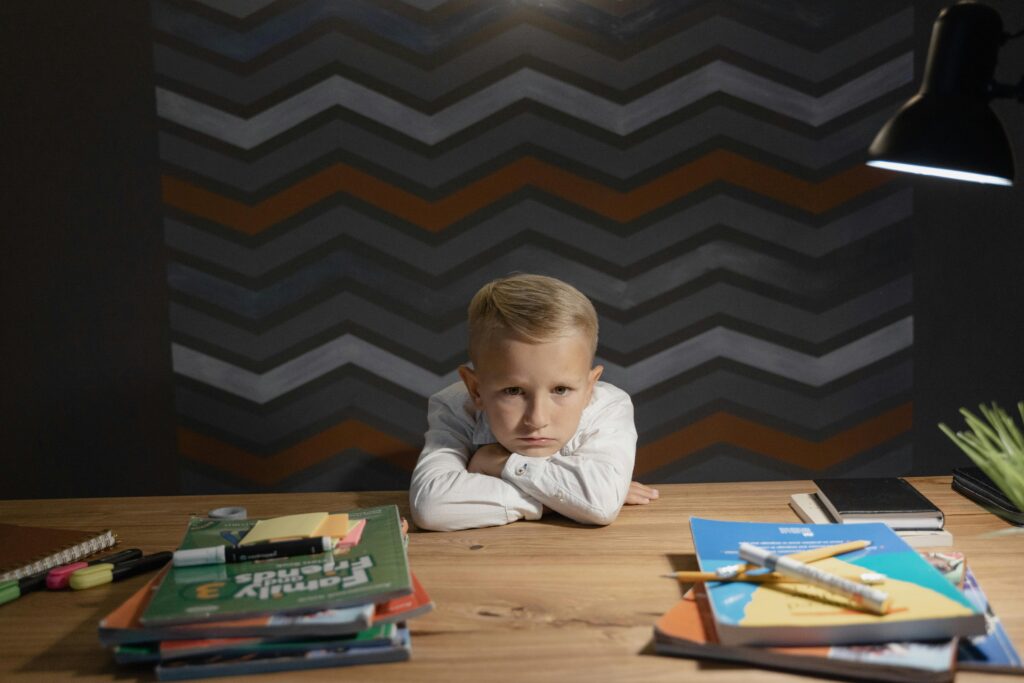 Little Boy with His Head Down on a Desk