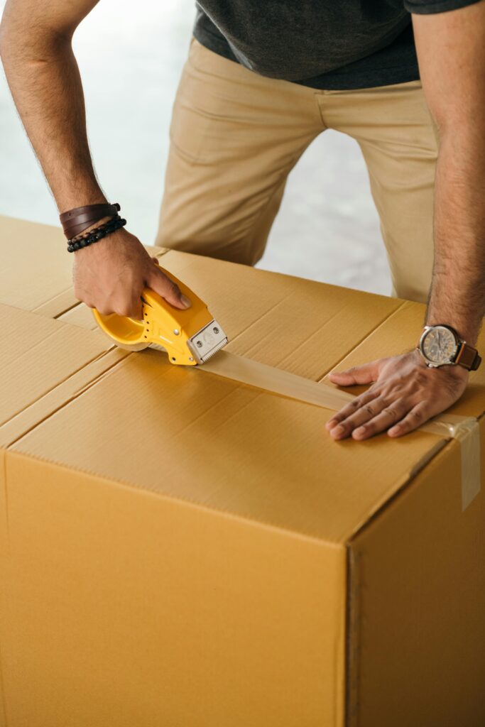 Man Taping a Box Closed